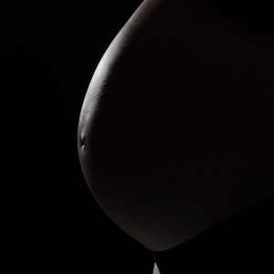Prise de vue maternité noir et blanc avec lumière rasante en contre-jour - femme enceinte joli ventre rond - Image Pro Photolouis